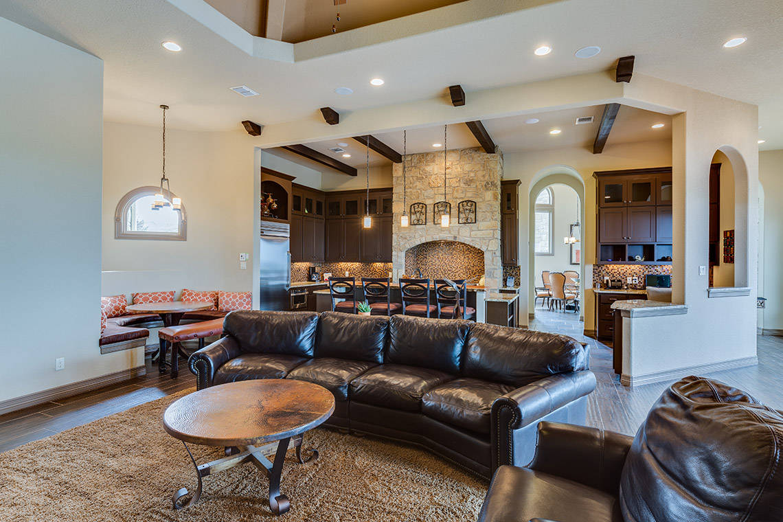 living area with leather couches and kitchen